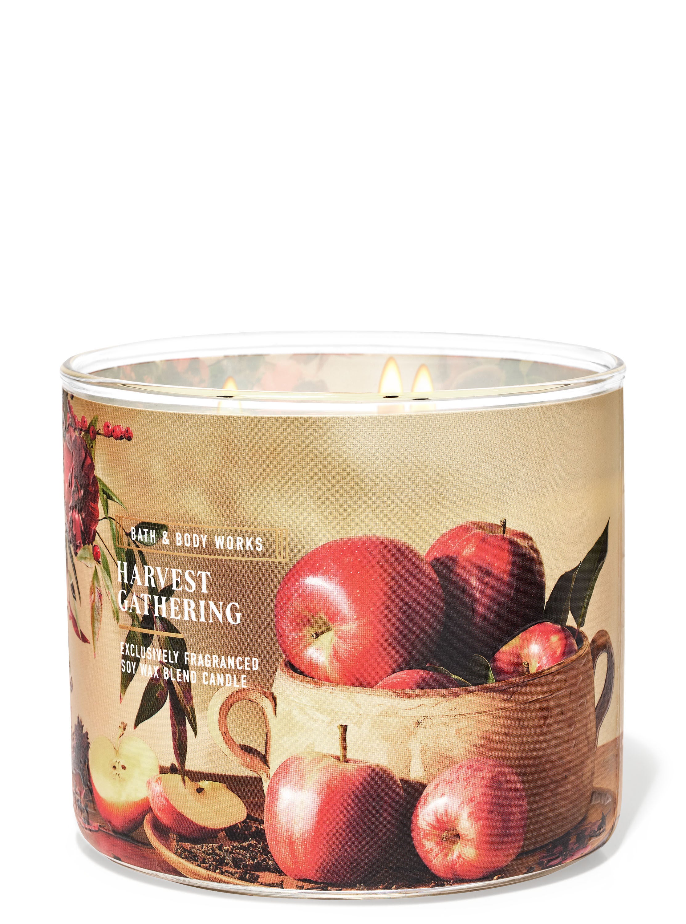 A glass jar 3-wick candle with a label on it showing a photo of apples in a bowl